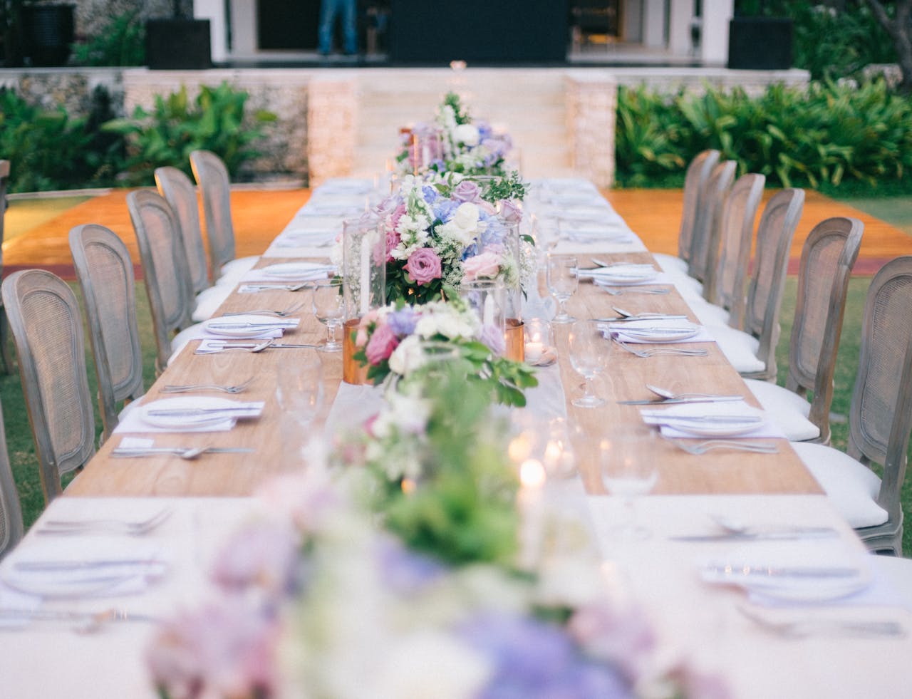 Beautifully decorated outdoor table with floral arrangements, perfect for a wedding or fine dining event.